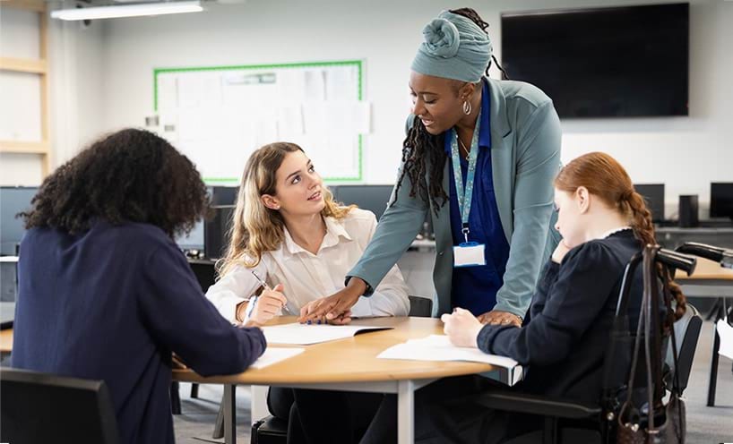 A teacher instructs a group of female adolescent students, one student uses a wheelchair