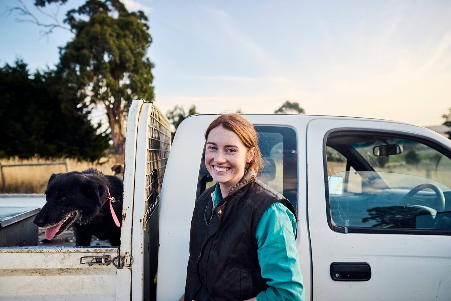 Young farm worker with ute and dog