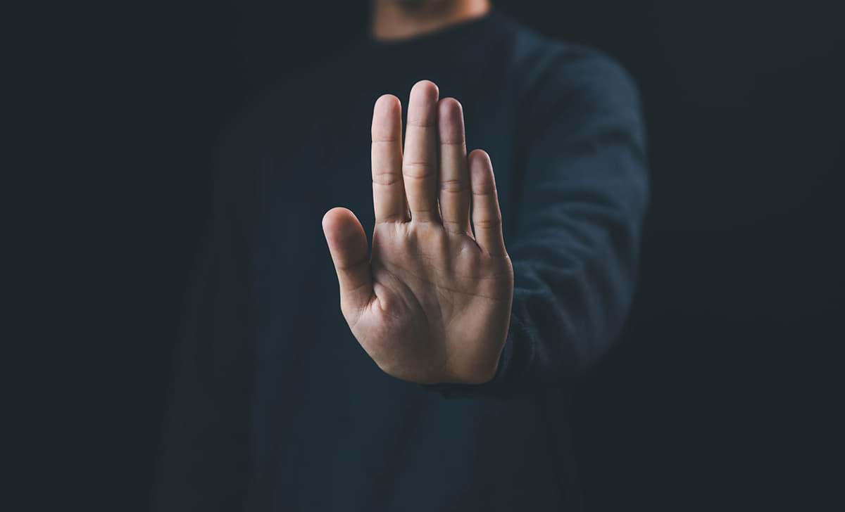 A man makes a hand gesture indicating, 'stop, caution"