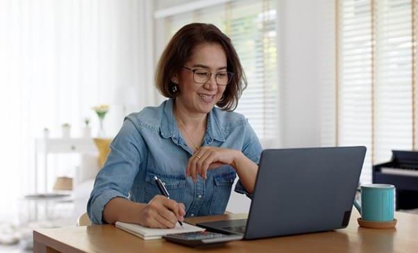 Image of person on laptop taking notes