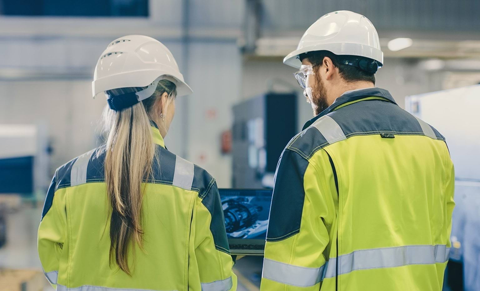 Colleagues in high viz and hard hats in an industrial plant