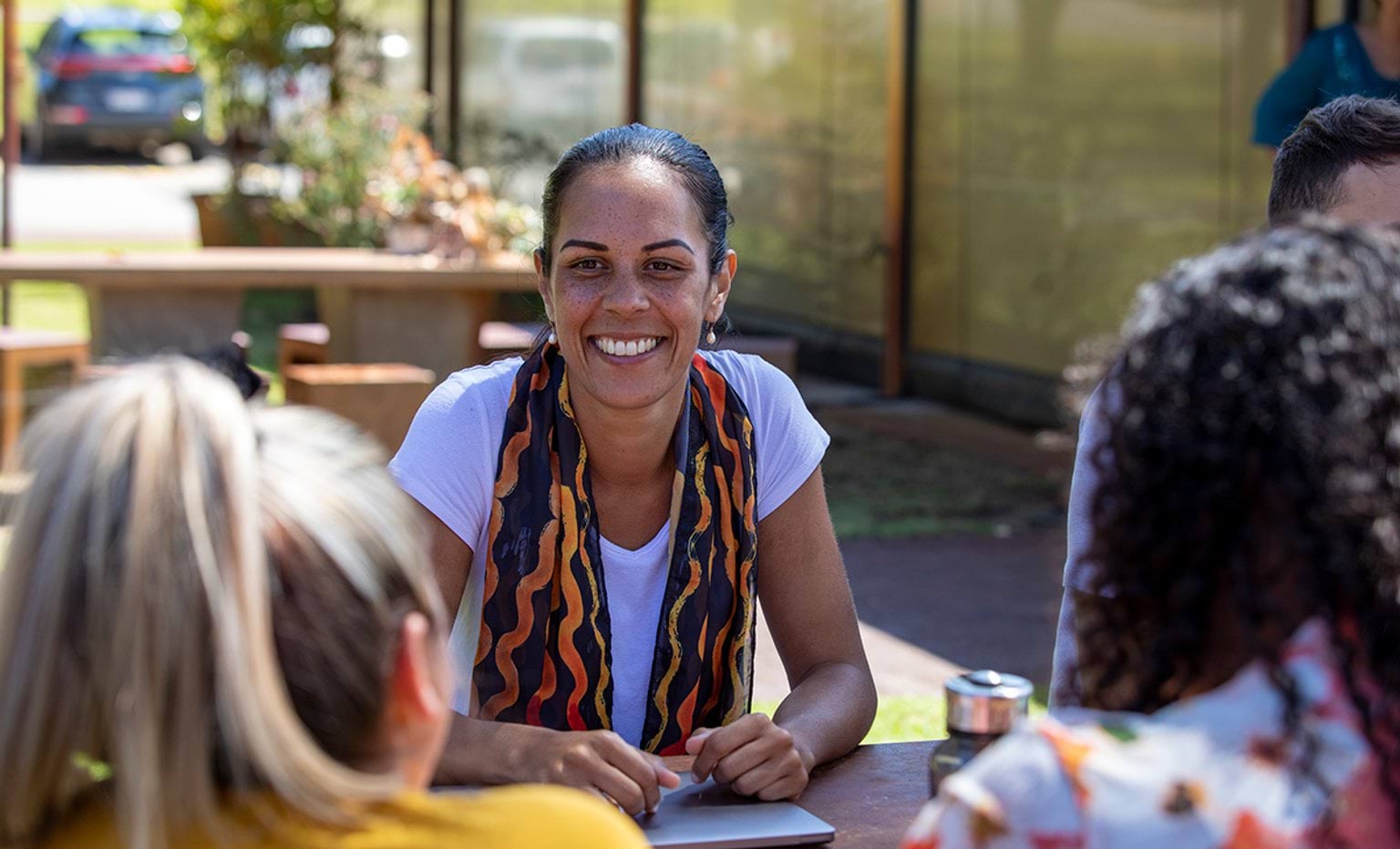 Close-up of young Aboriginal students studying together outdoors in the sun in Australia