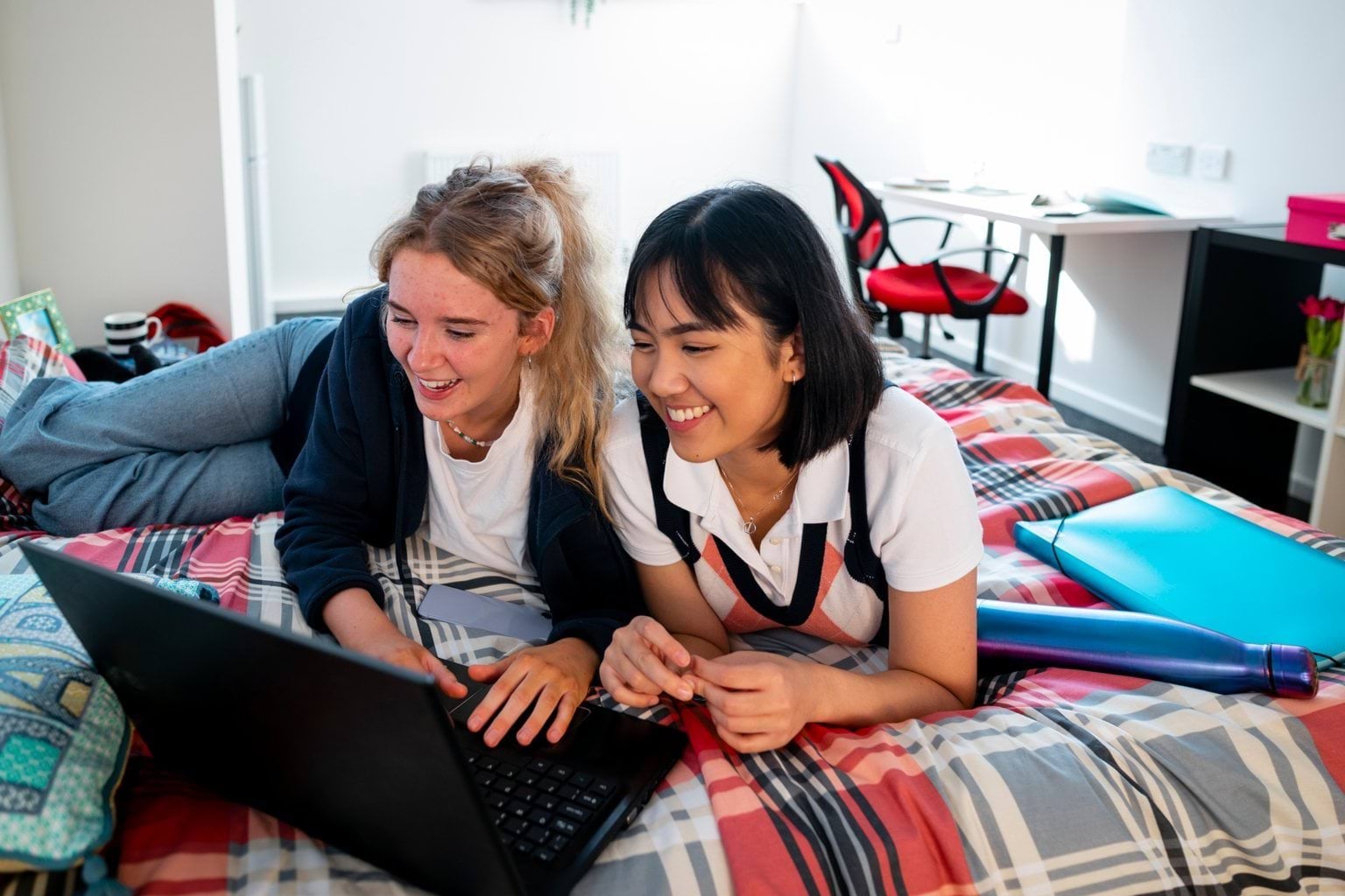Two students on a laptop in the bedroom of a school boarding premises