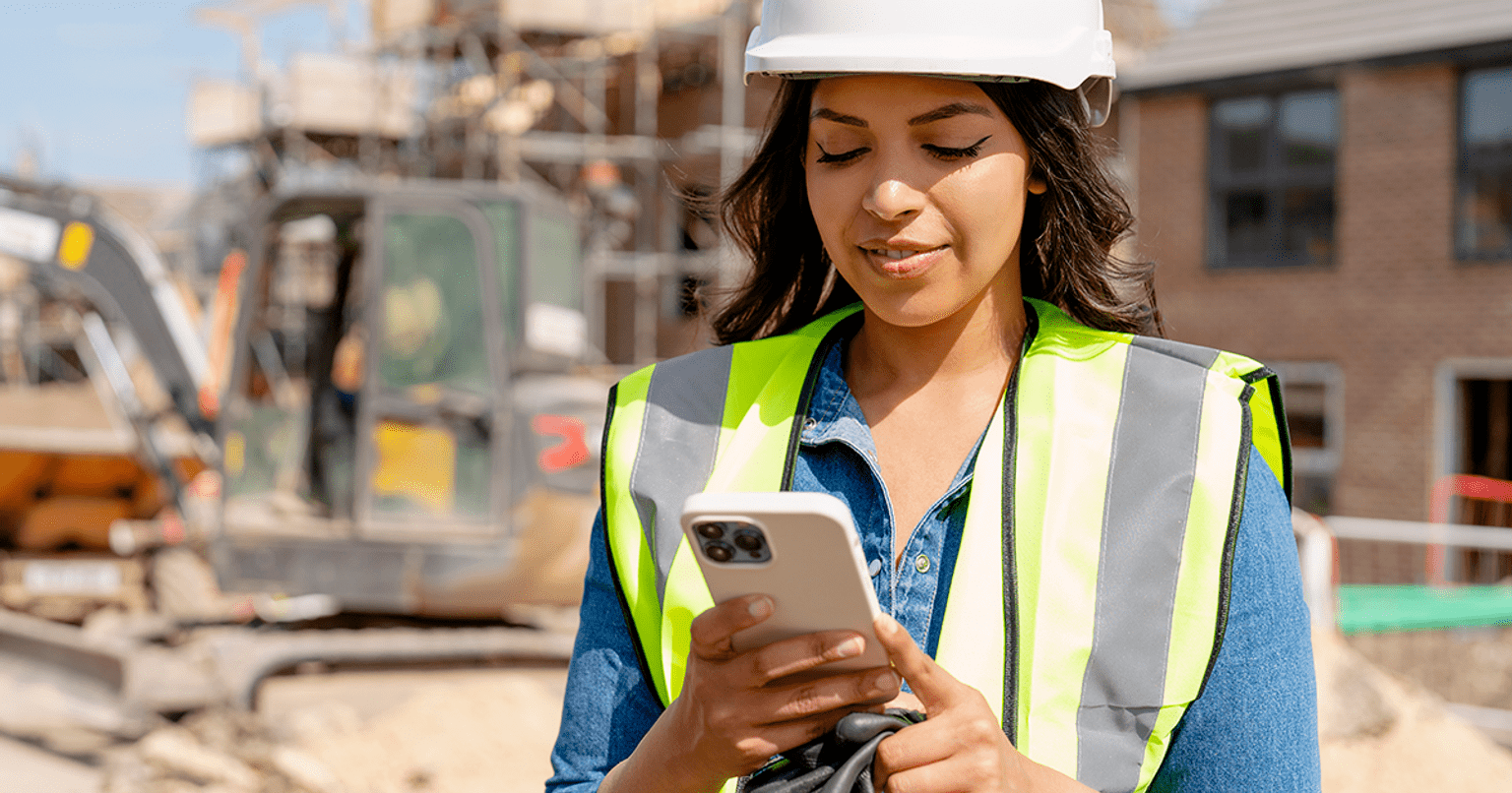 Female construction worker looking at her phone