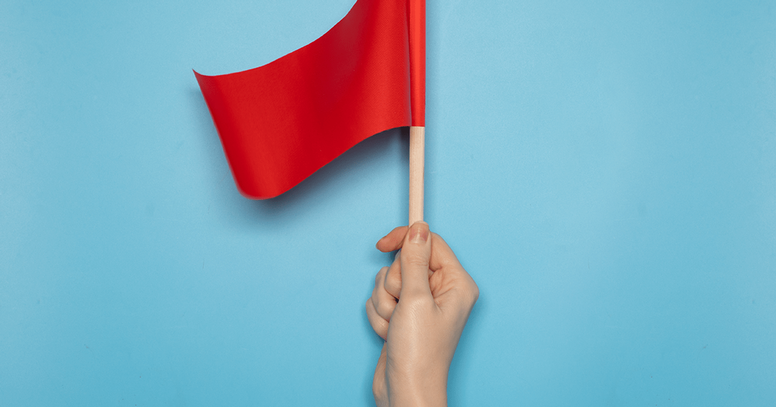 A hand waves a red flag